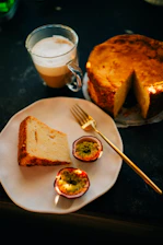 Close-up of an elegant slice of passion fruit cake on a cream plate with subtle gold accents.