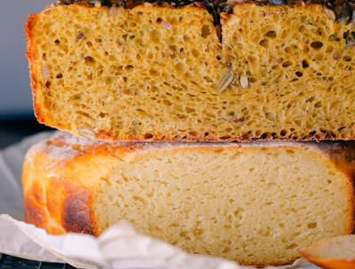 Freshly baked multigrain bread with seeds sprinkled on top, cooling on a linen cloth.