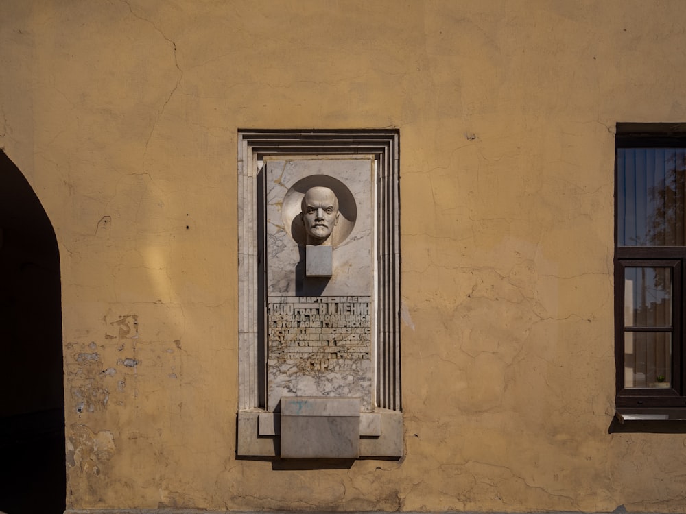 a statue of a man's head on the side of a building