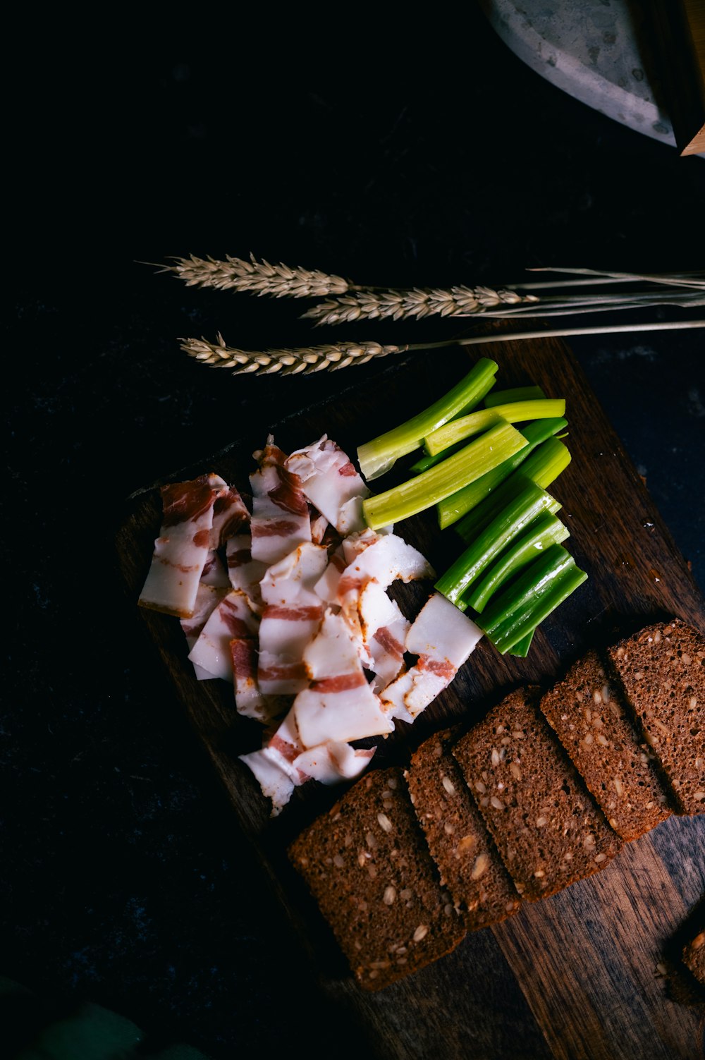 a wooden cutting board topped with meat and vegetables