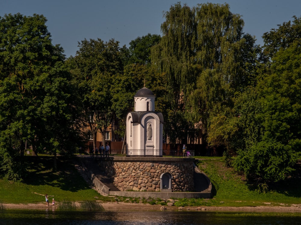a clock tower sitting on the side of a river