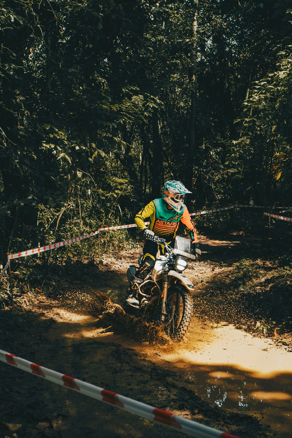 a man riding a dirt bike on a dirt road