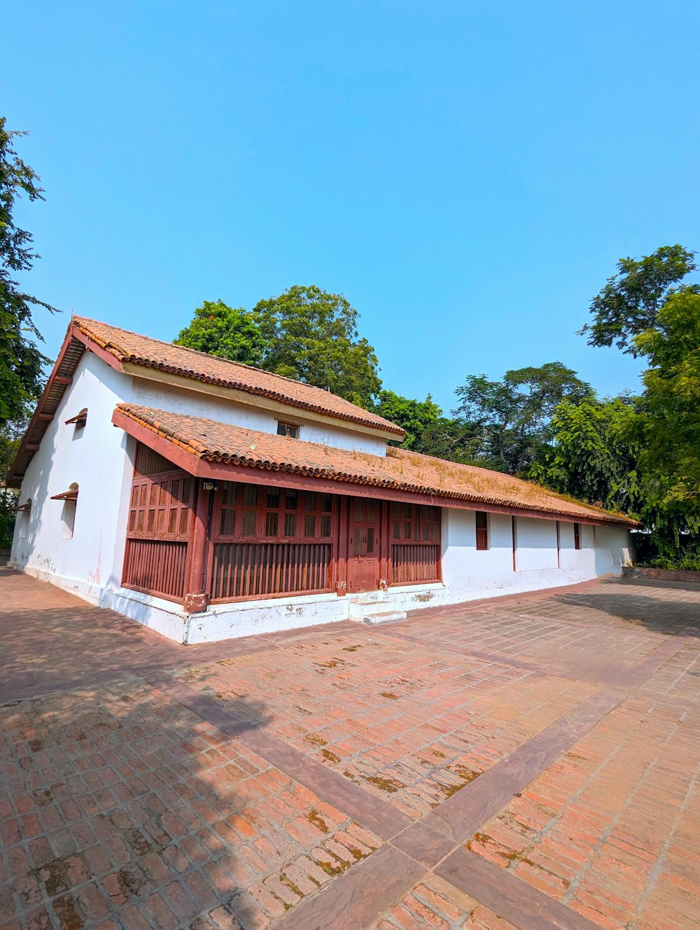 a white building with a red roof and a red door