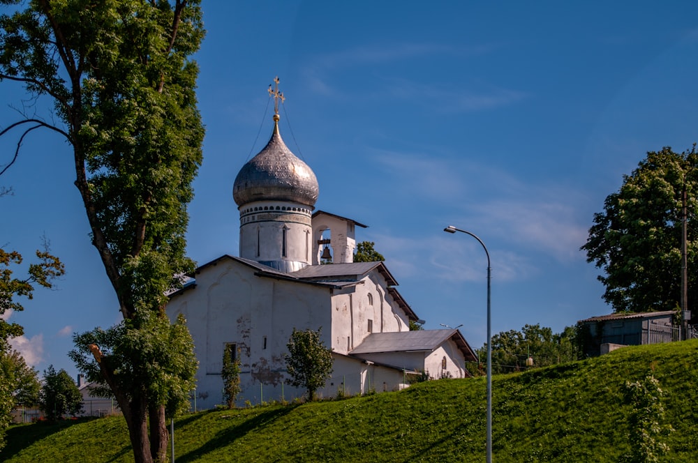 a white church with a steeple on a hill