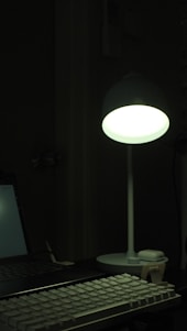 A warm workspace featuring intricately detailed 3D printed keychains and a lithophone moon glowing gently in soft light.