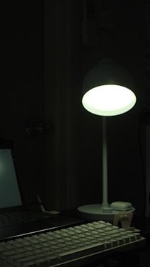 A cozy workspace with a glowing keyboard and a laptop displaying the typemaster typing test interface.