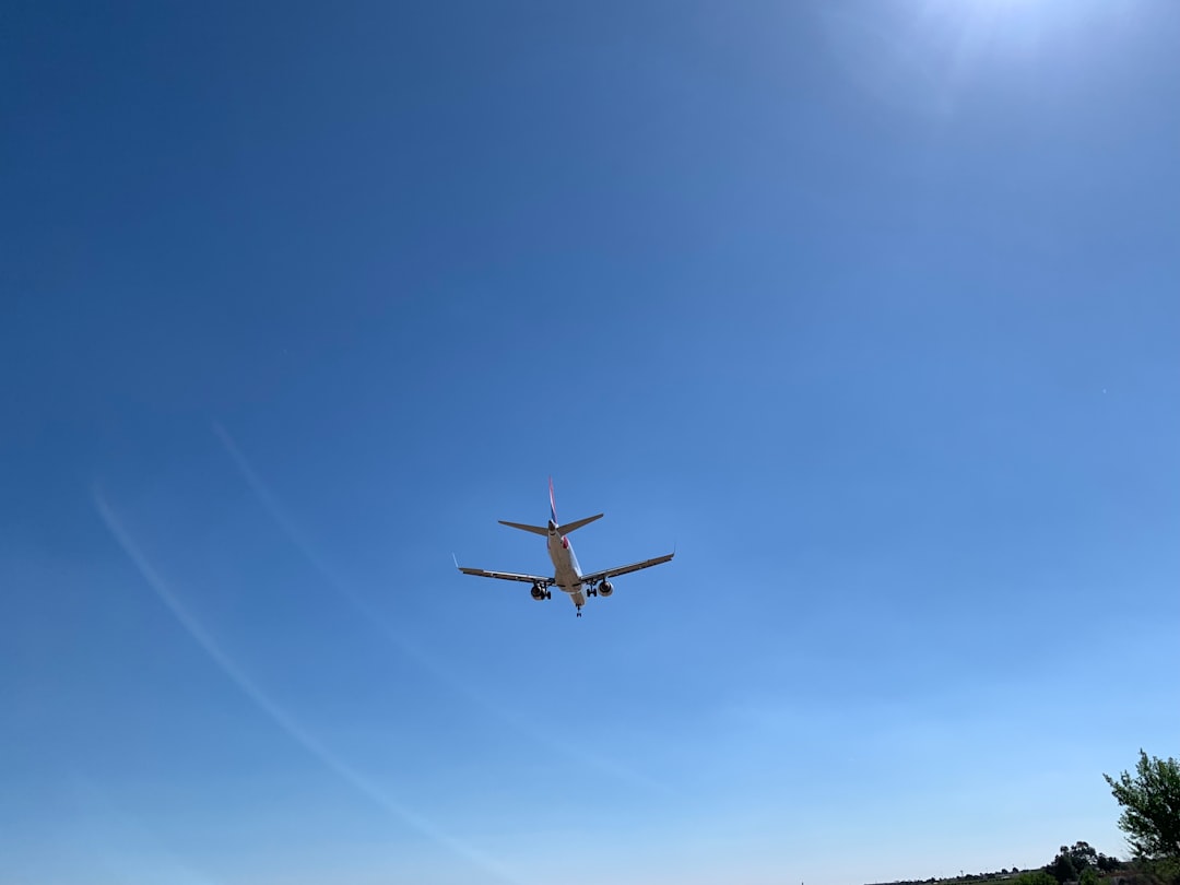an airplane is flying in the blue sky, Plane landing at Manises airport, Valencia, Spain, Europe