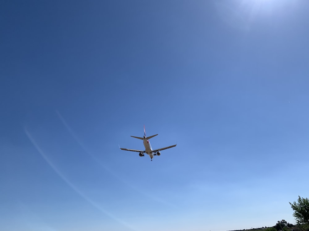 an airplane is flying in the blue sky