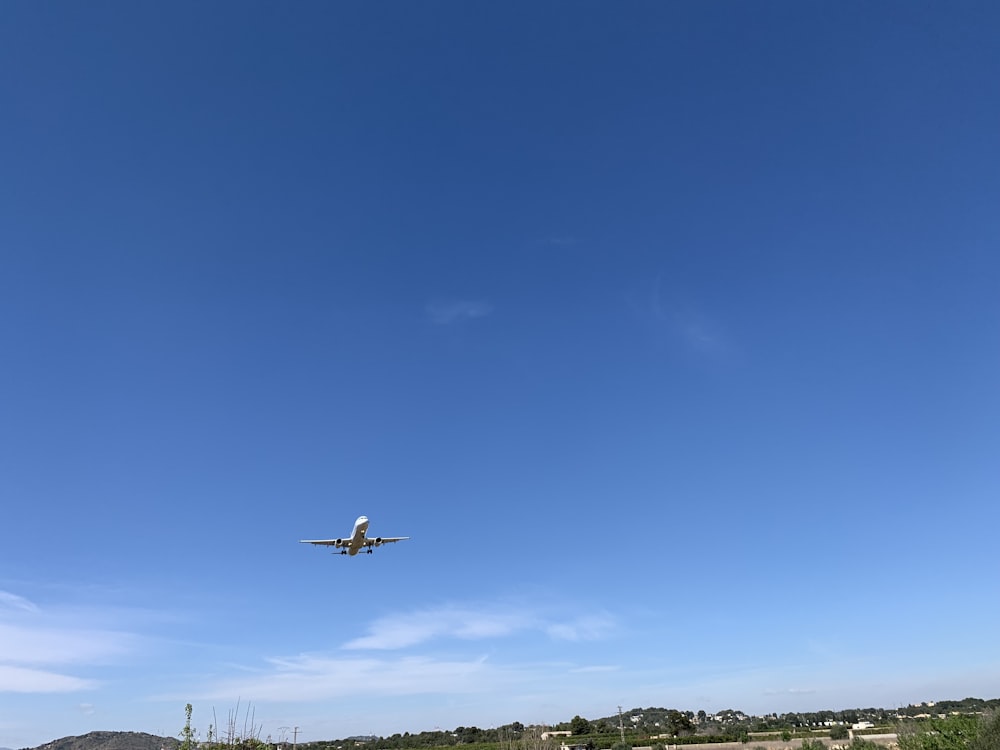 an airplane is flying in the blue sky