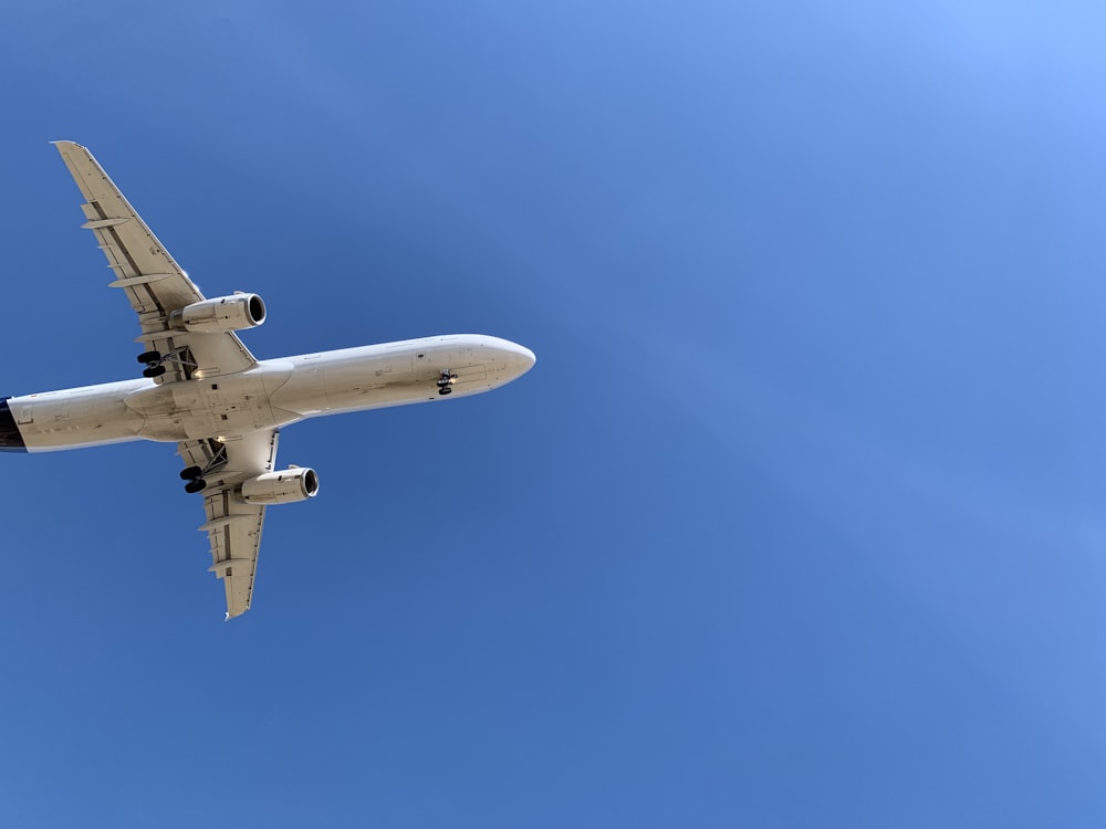 un grande aereo di linea che vola attraverso un cielo blu