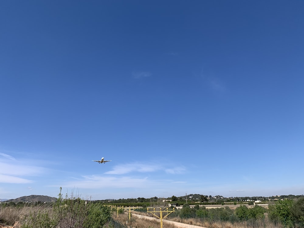 an airplane is flying over a dirt road