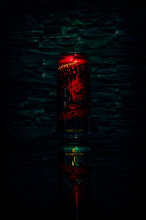 A vibrant can of neverdragme energy drink surrounded by dynamic splashes of energy and light.