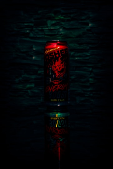 Close-up of a vibrant red energy drink can with droplets of condensation, set against a bright background.