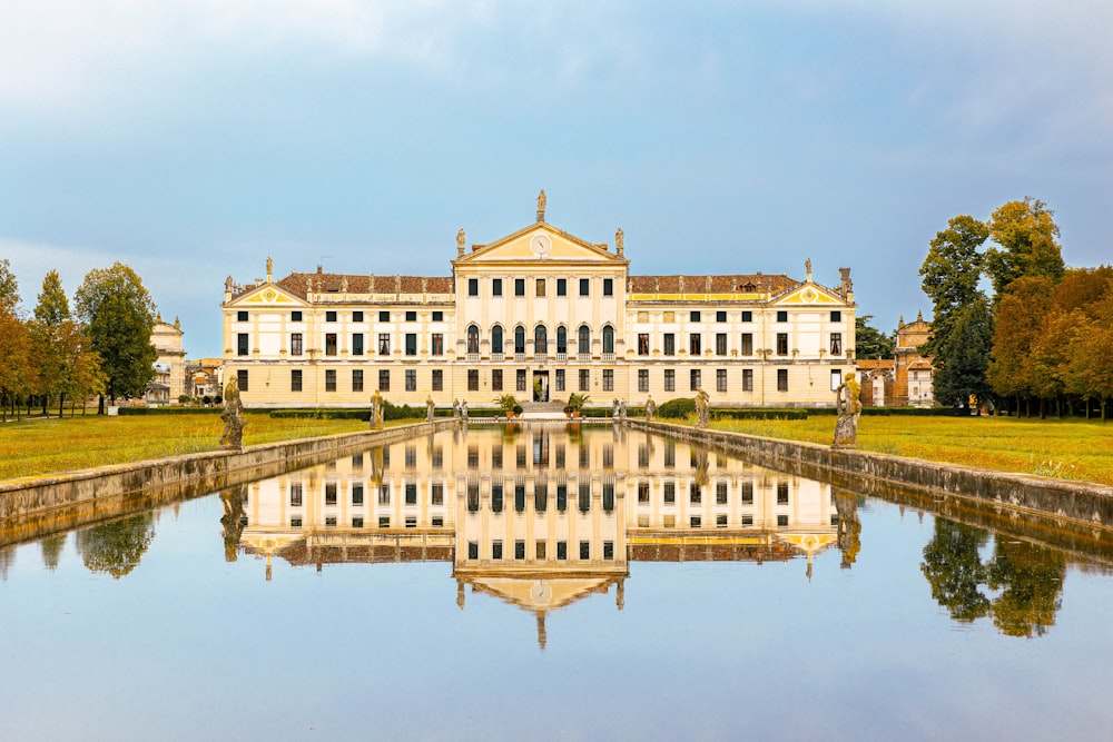 a large white building with a pond in front of it