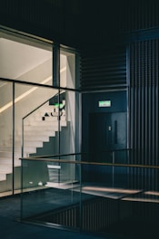 a stairwell leading up to a building with glass walls