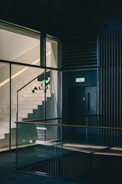 a stairwell leading up to a building with glass walls