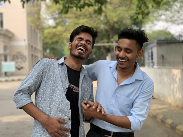A young man and his coach sharing a laugh during an outdoor mentoring session.
