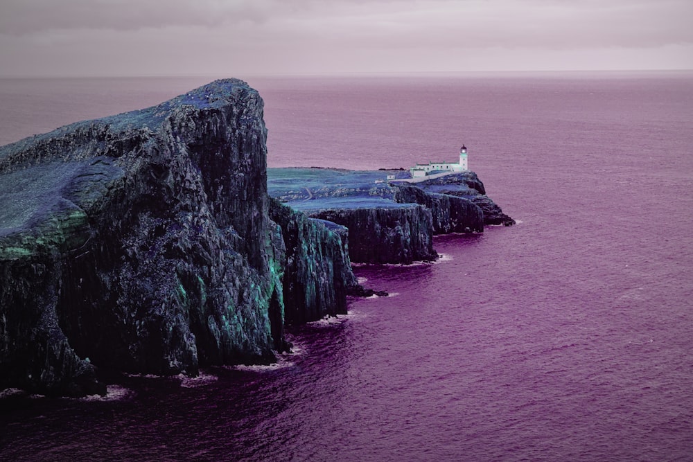 a lighthouse on an island in the middle of the ocean