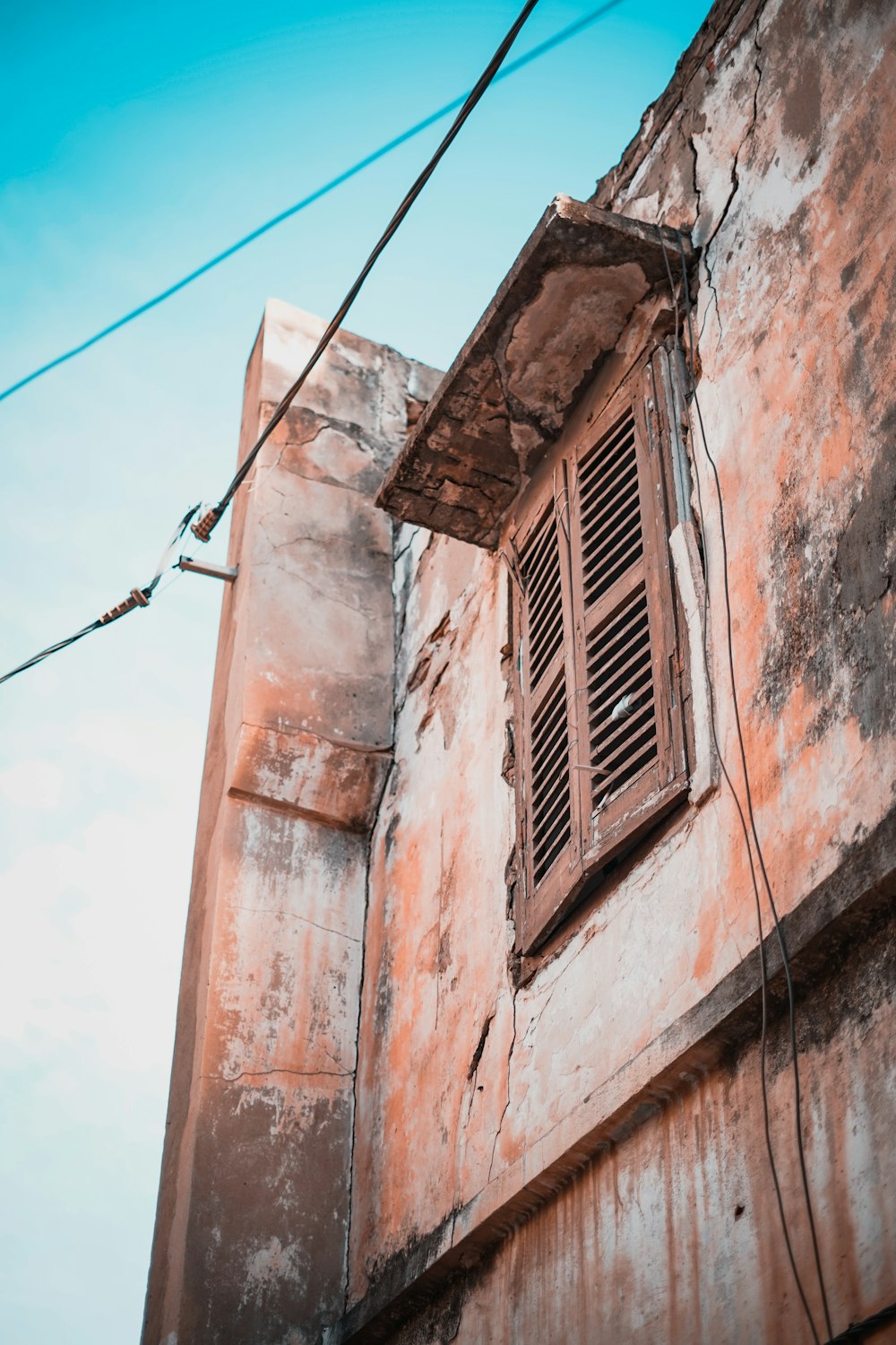 an old building with a broken window and wires