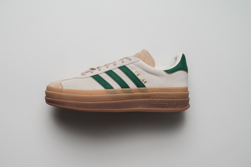 a white and green adidas sneakers on a white surface
