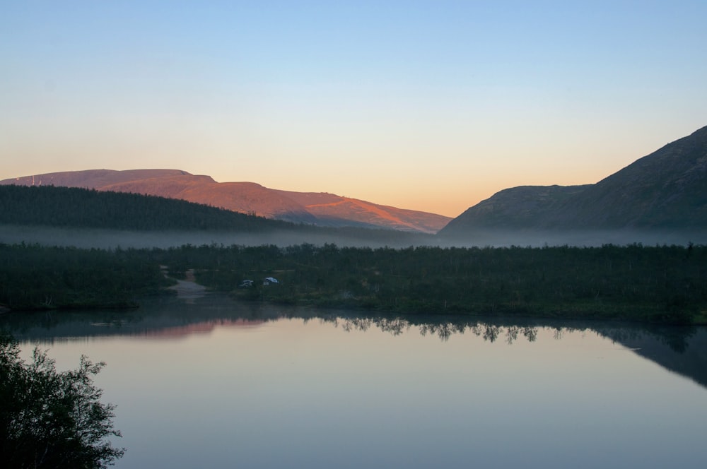 a body of water surrounded by mountains and trees