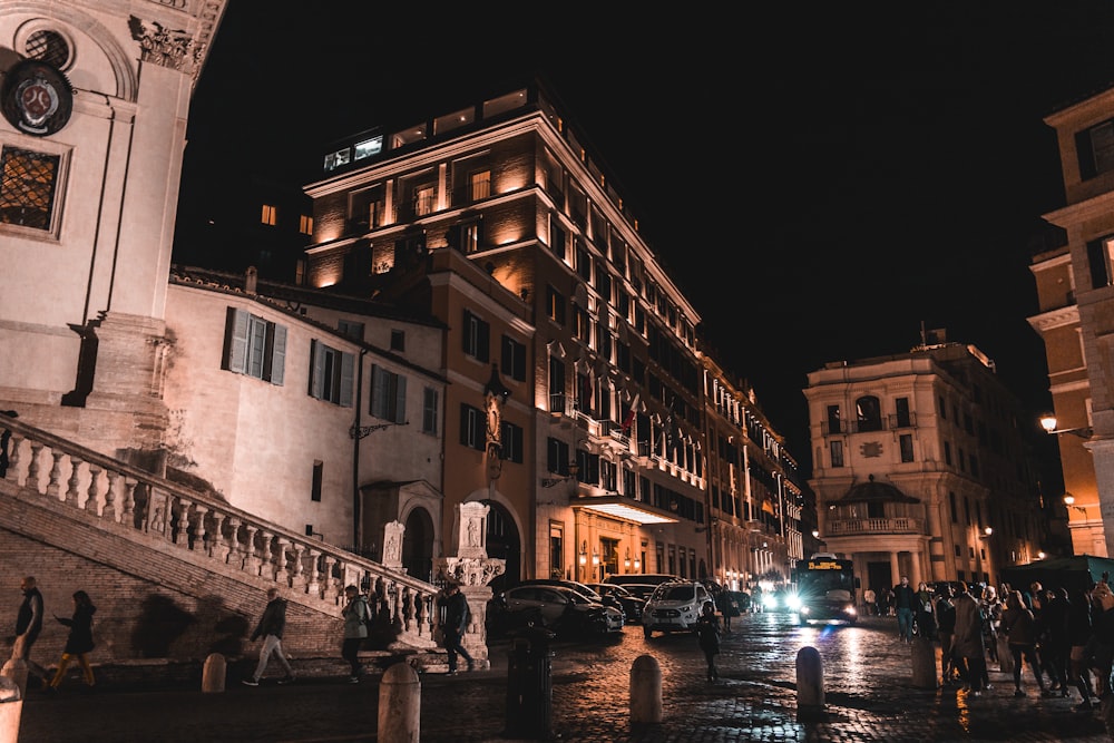 a group of people walking down a street at night