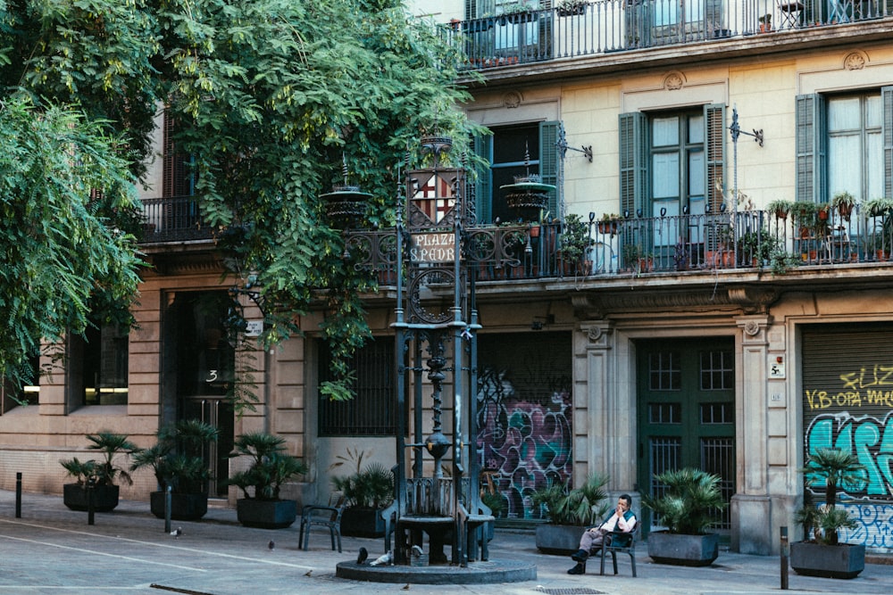 a person sitting on a bench in front of a building