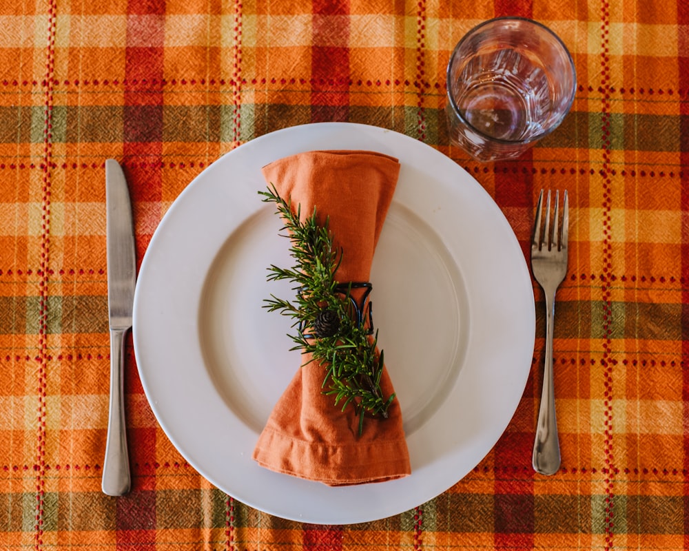 a white plate topped with an orange napkin