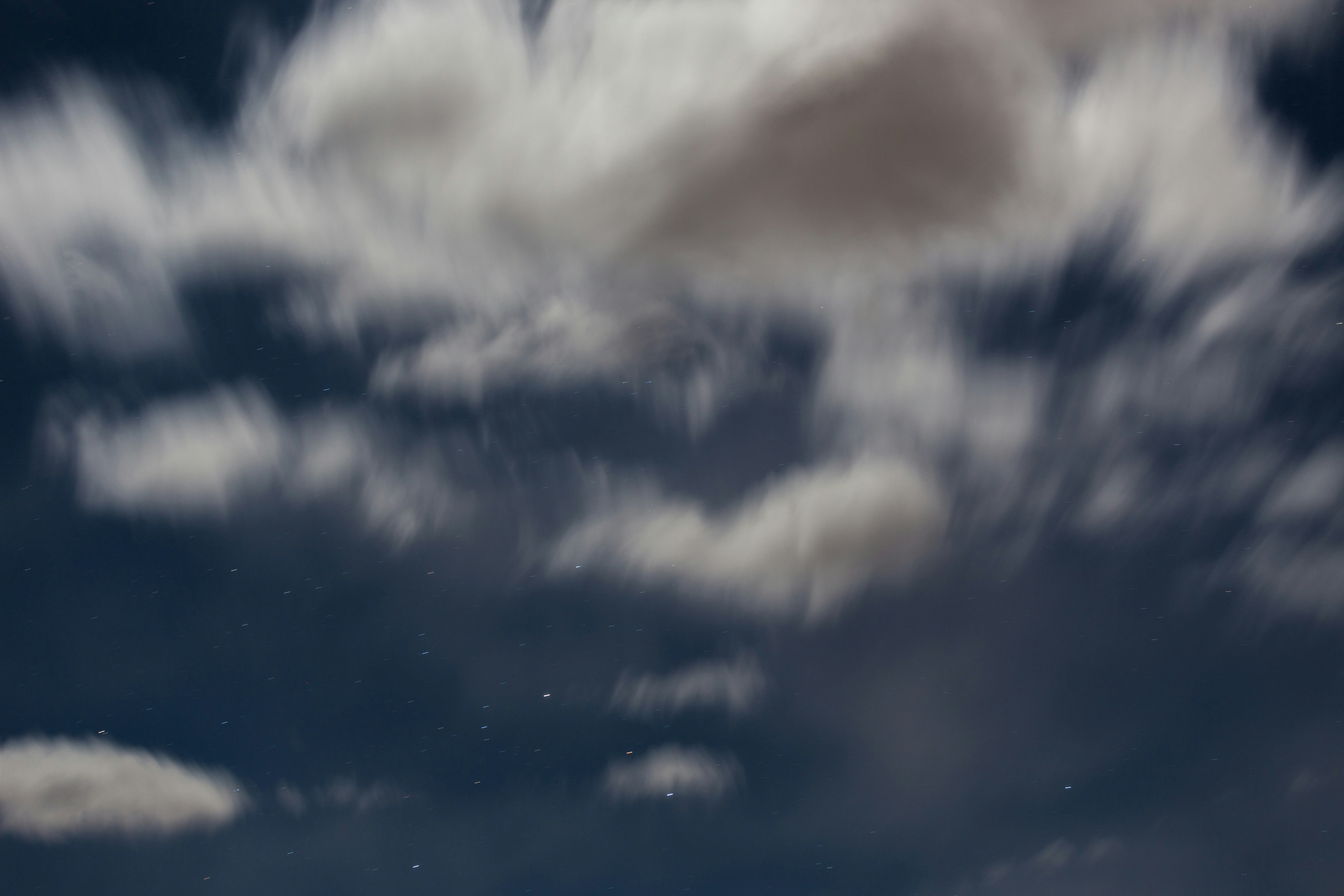 the night sky is full of clouds and stars