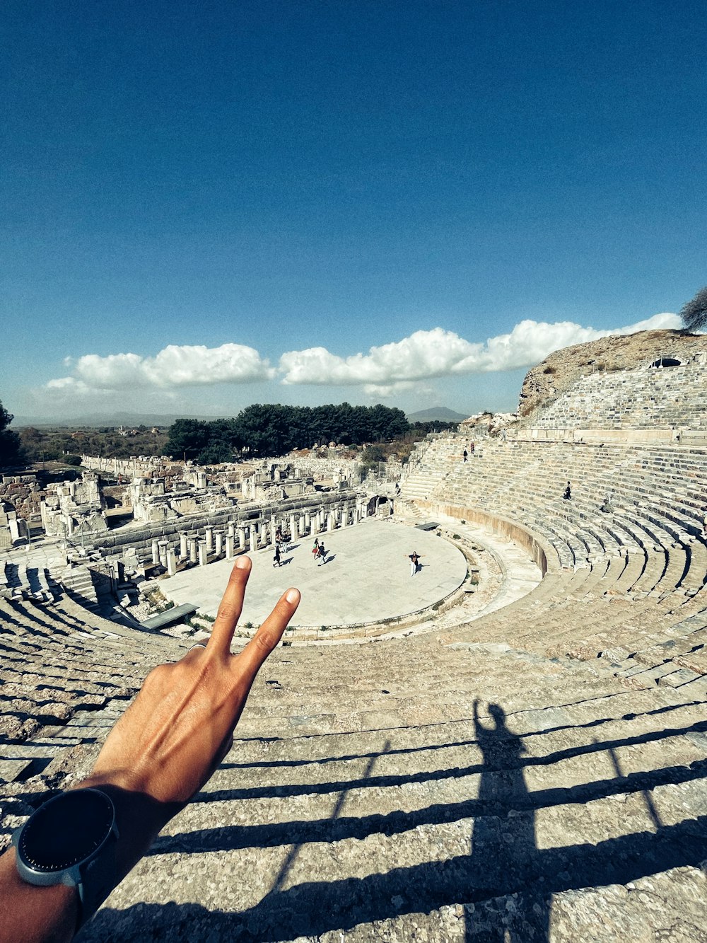 a hand pointing at a roman amphit