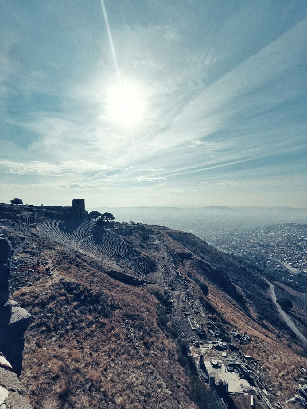 a person sitting on top of a hill overlooking a city