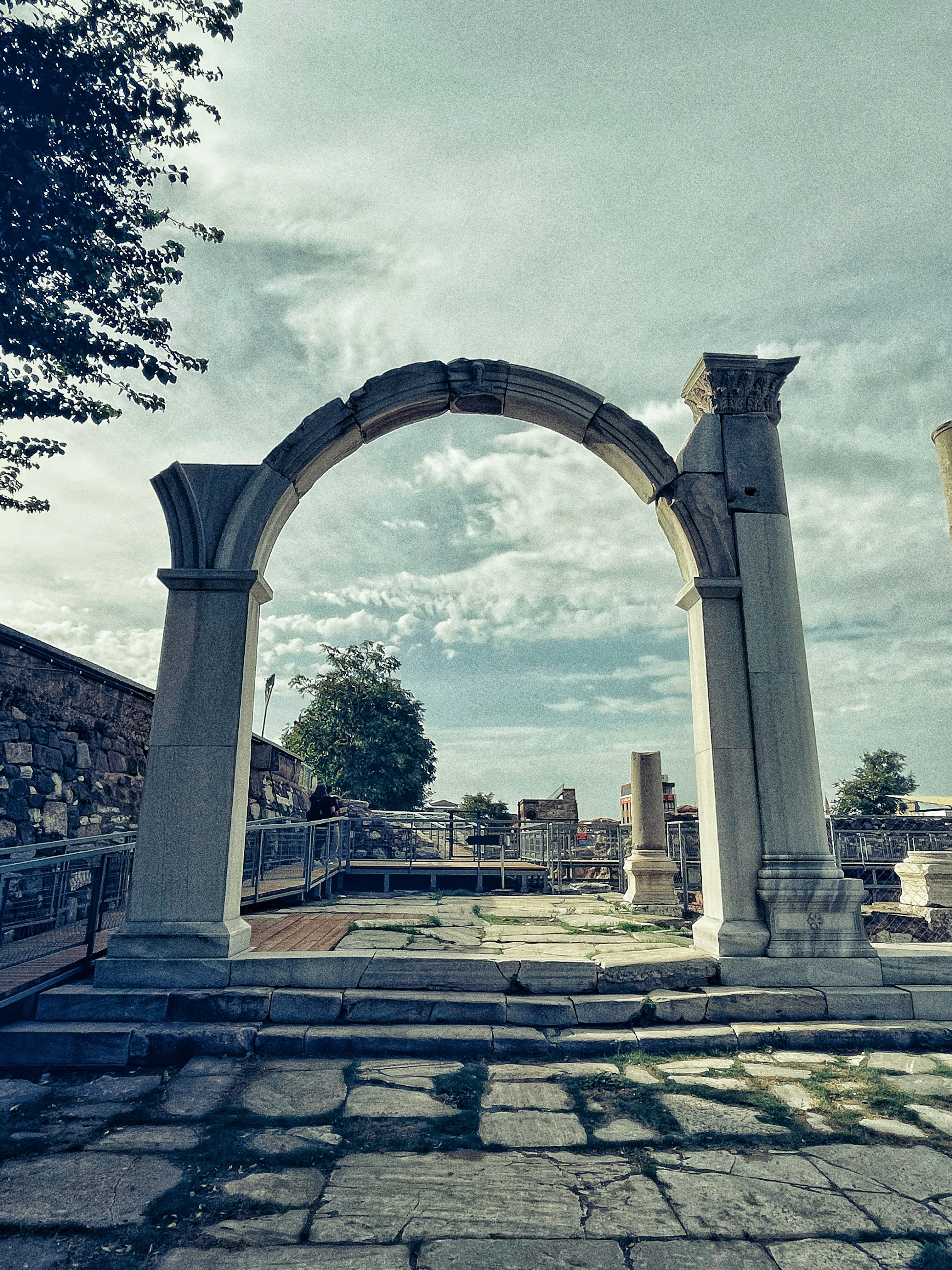 an arch in the middle of a stone walkway