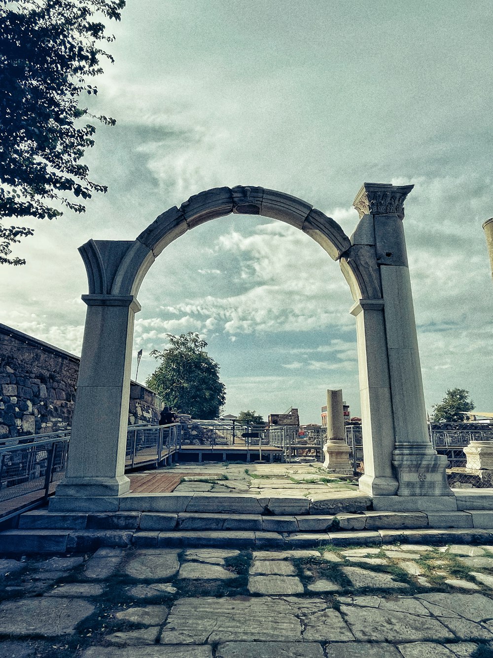 an arch in the middle of a stone walkway