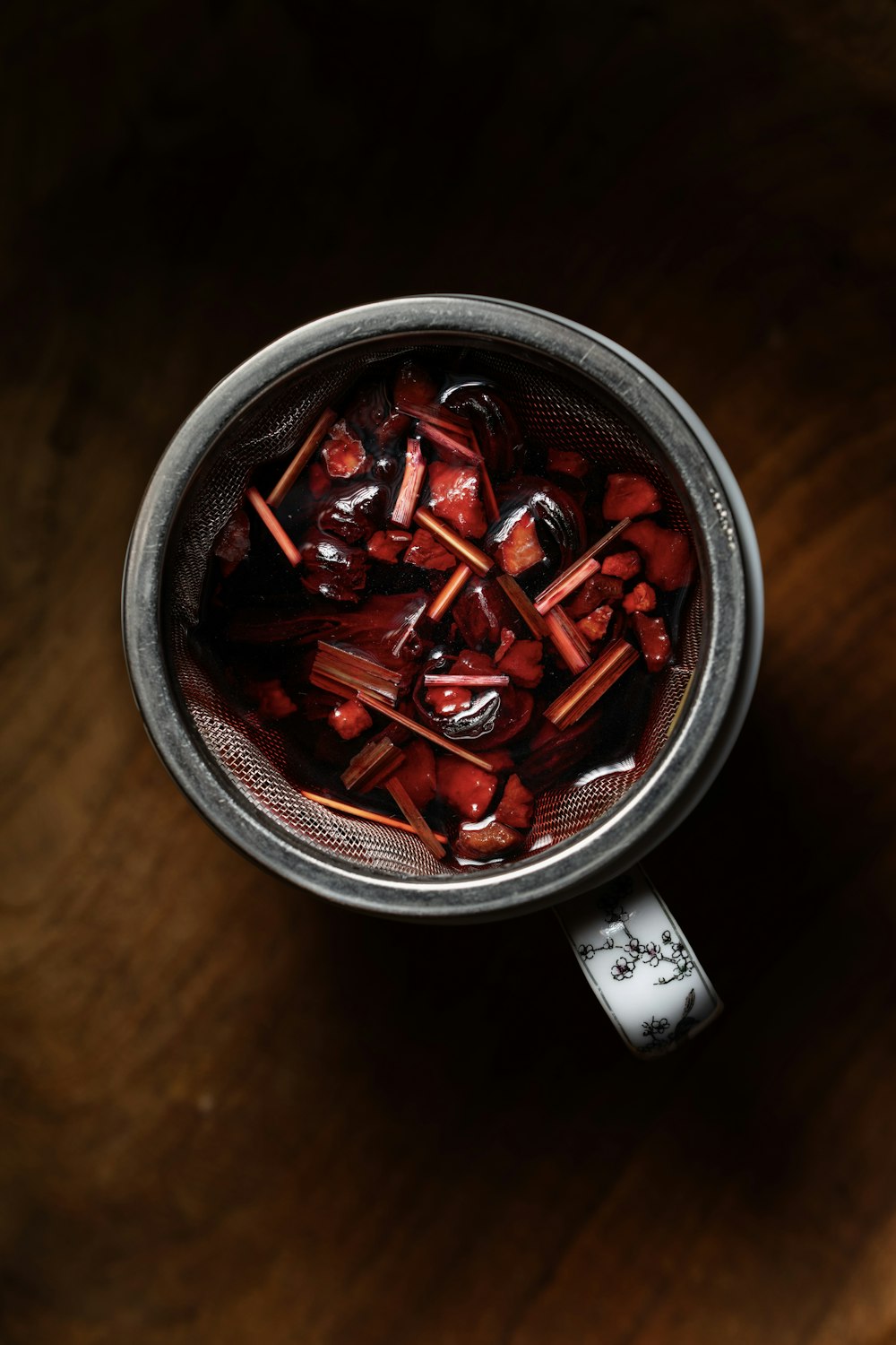 a metal cup filled with lots of red candies
