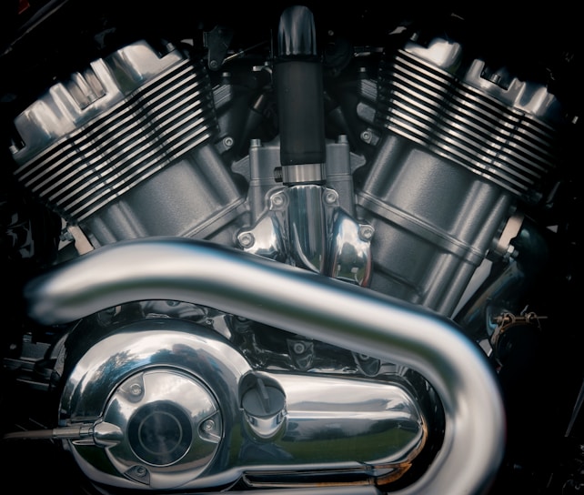A close-up of a motorcycle engine part on a workbench.