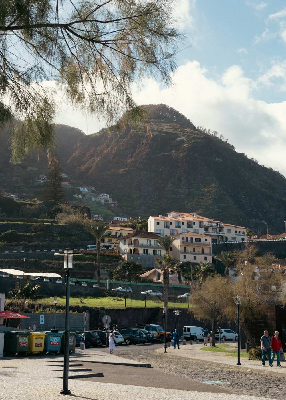 a group of people walking down a street next to a mountain