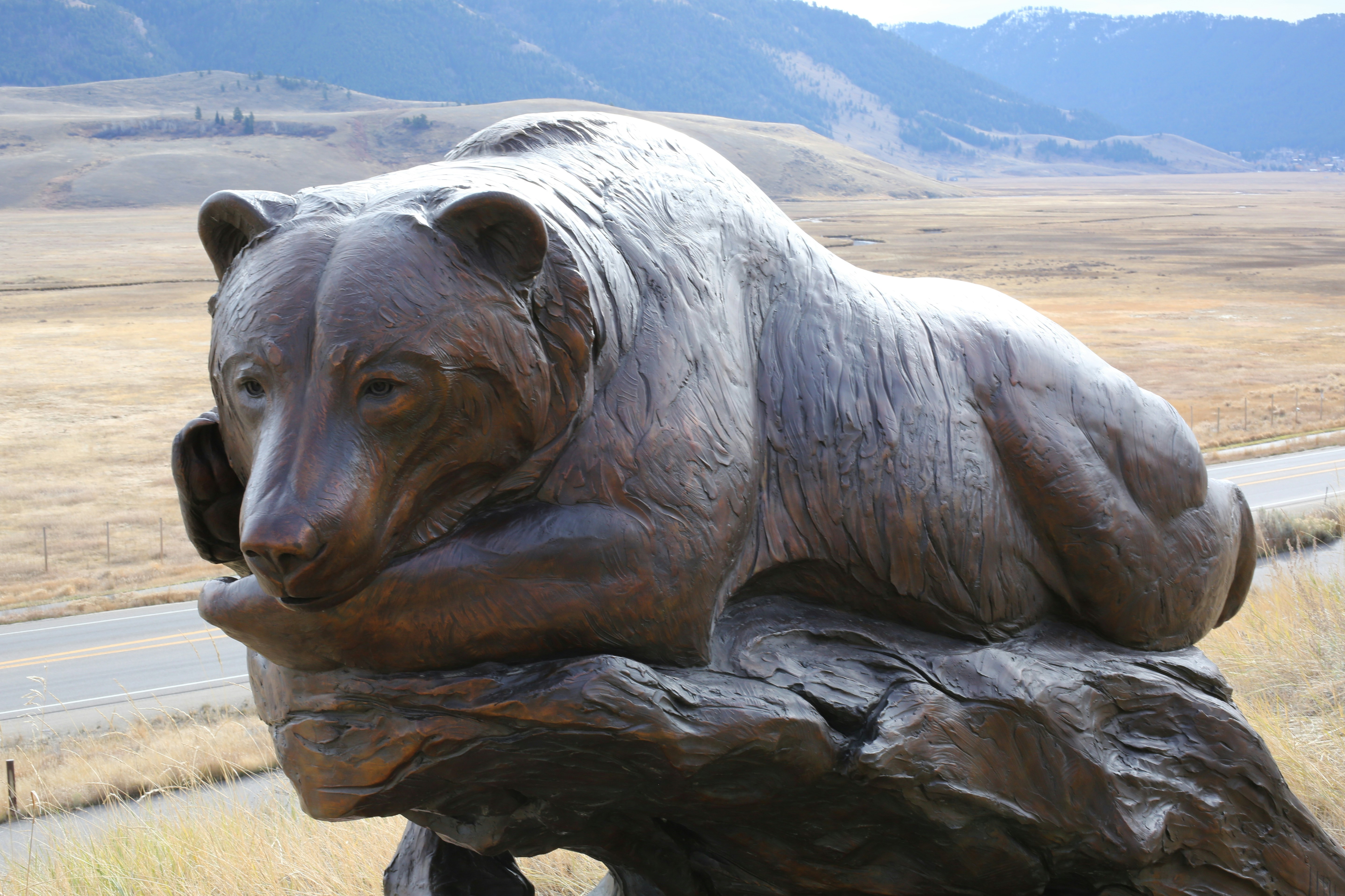a statue of a bear sitting on a log
