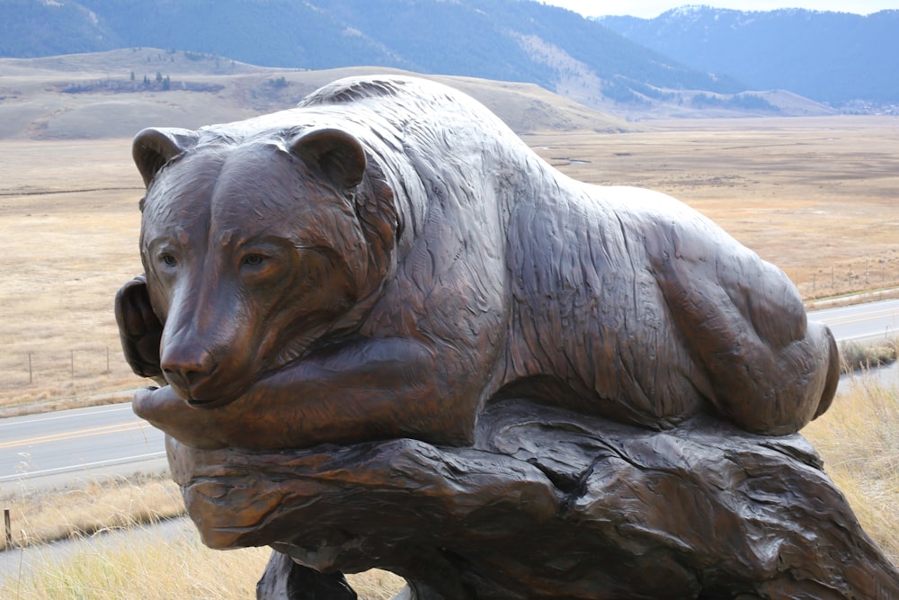 a statue of a bear sitting on a log