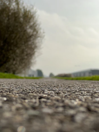 A freshly graded driveway with smooth gravel laid out under a cloudy sky.