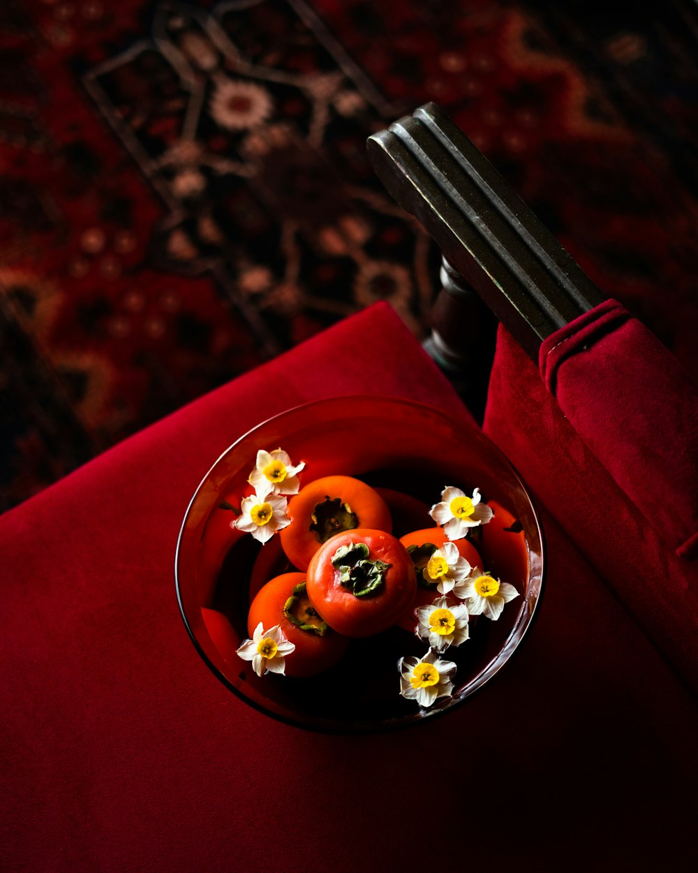 uma tigela cheia de pimentas e flores em cima de uma mesa