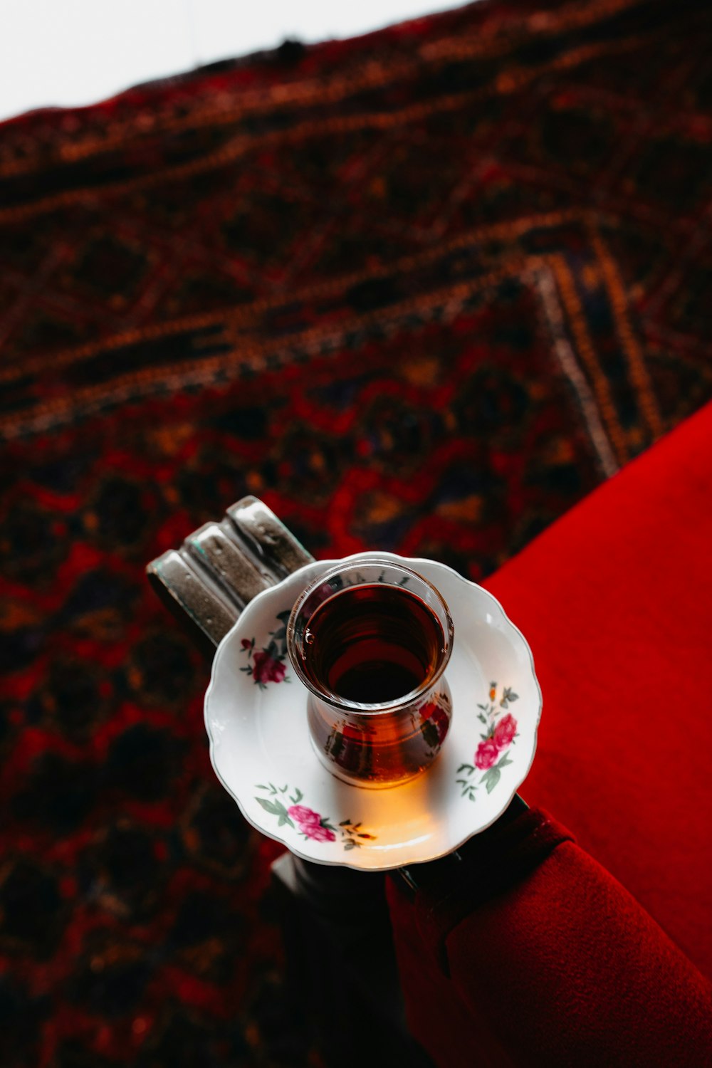 a person holding a cup of tea on a saucer