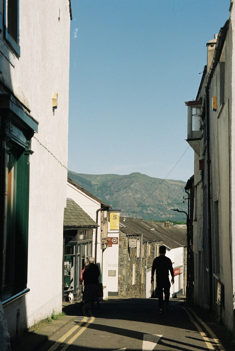 a man riding a bike down a street next to tall buildings