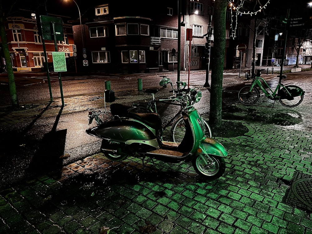 a green scooter parked on the side of a street