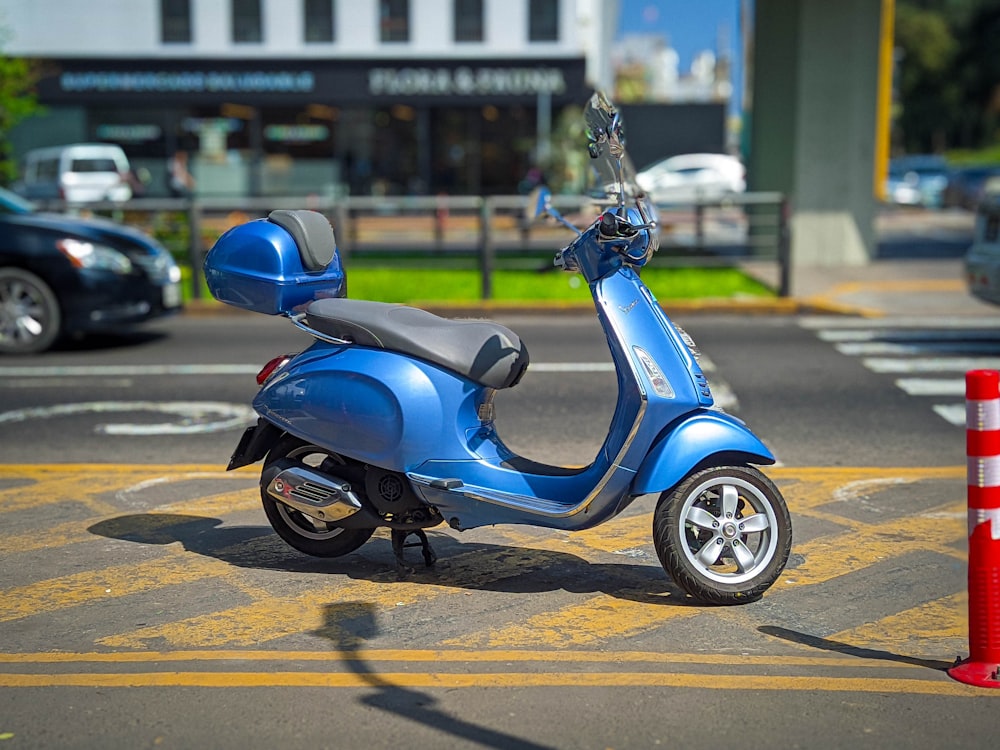 a blue scooter is parked in a parking lot