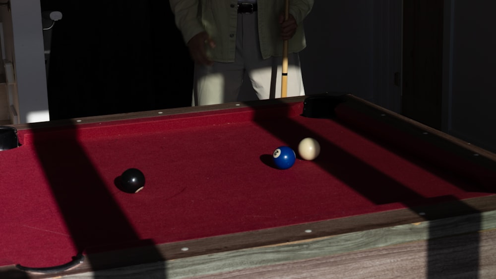 a man standing next to a pool table