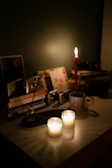 A cozy desk setup with candles, crystals, and an open astrological calendar.
