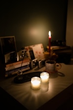A dark-themed workspace with books, candles, and vintage decor, creating an inspiring atmosphere for writing.