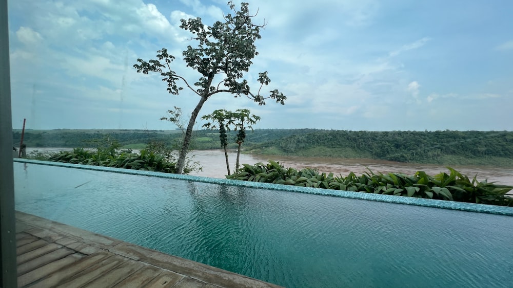 a pool with a view of a river and trees
