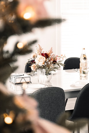 An elegant corporate meeting setup featuring neatly packed meal boxes alongside sparkling water bottles and fresh flowers.