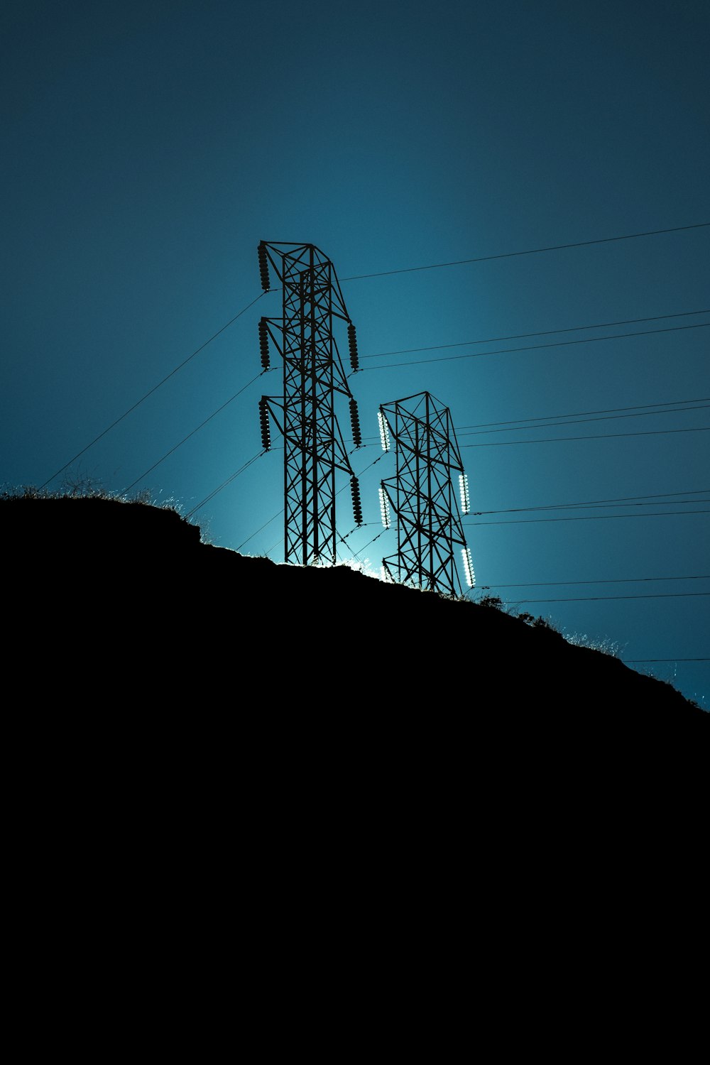 a silhouette of a person standing on top of a hill